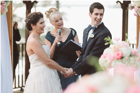 Wedding couple holding hands and laughing during ceremony