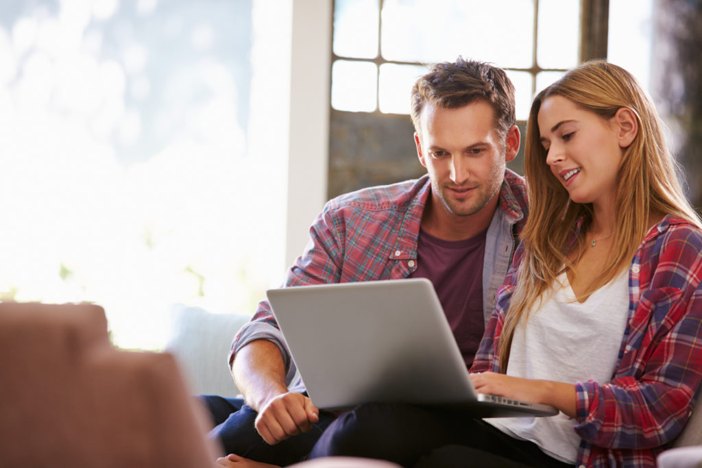 couple sitting together casually writing vows on computer